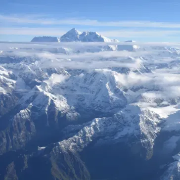 Snow topped Mountain range with cloudy sky background