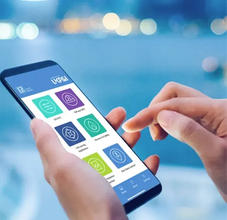 Hands holding a mobile phone showing the Lloyds Register Checklist application with bokeh lights in the background